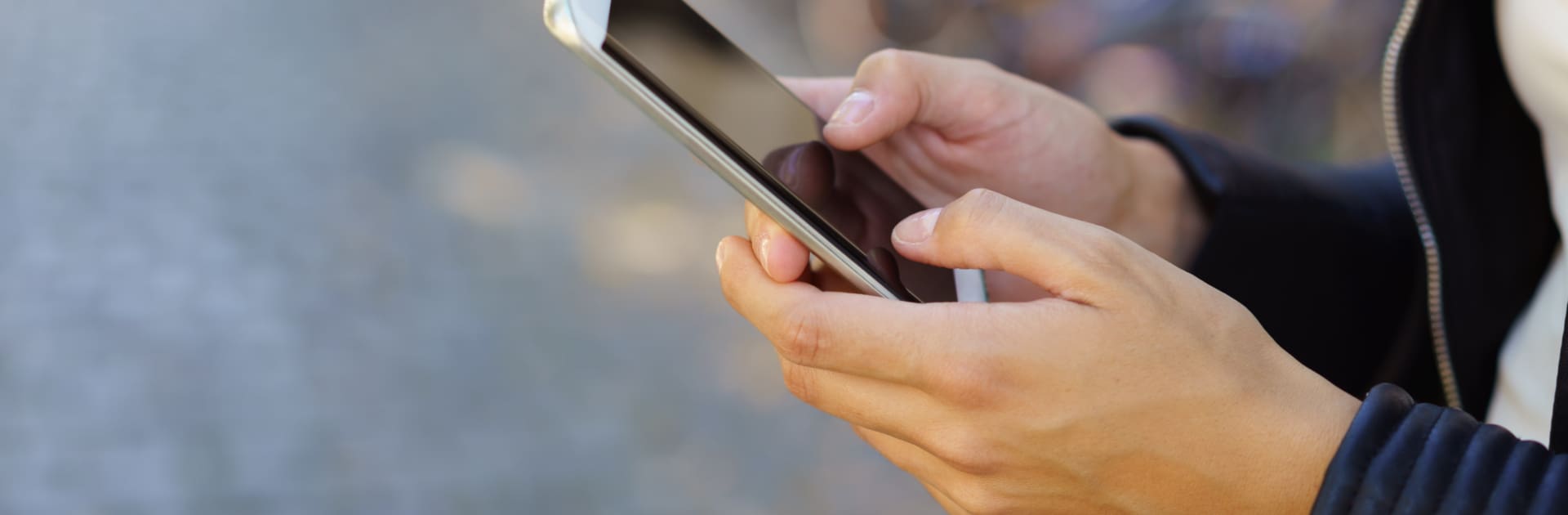 frau ist unterwegs und hält ihr mobiltelefon in der hand mobiltelefon